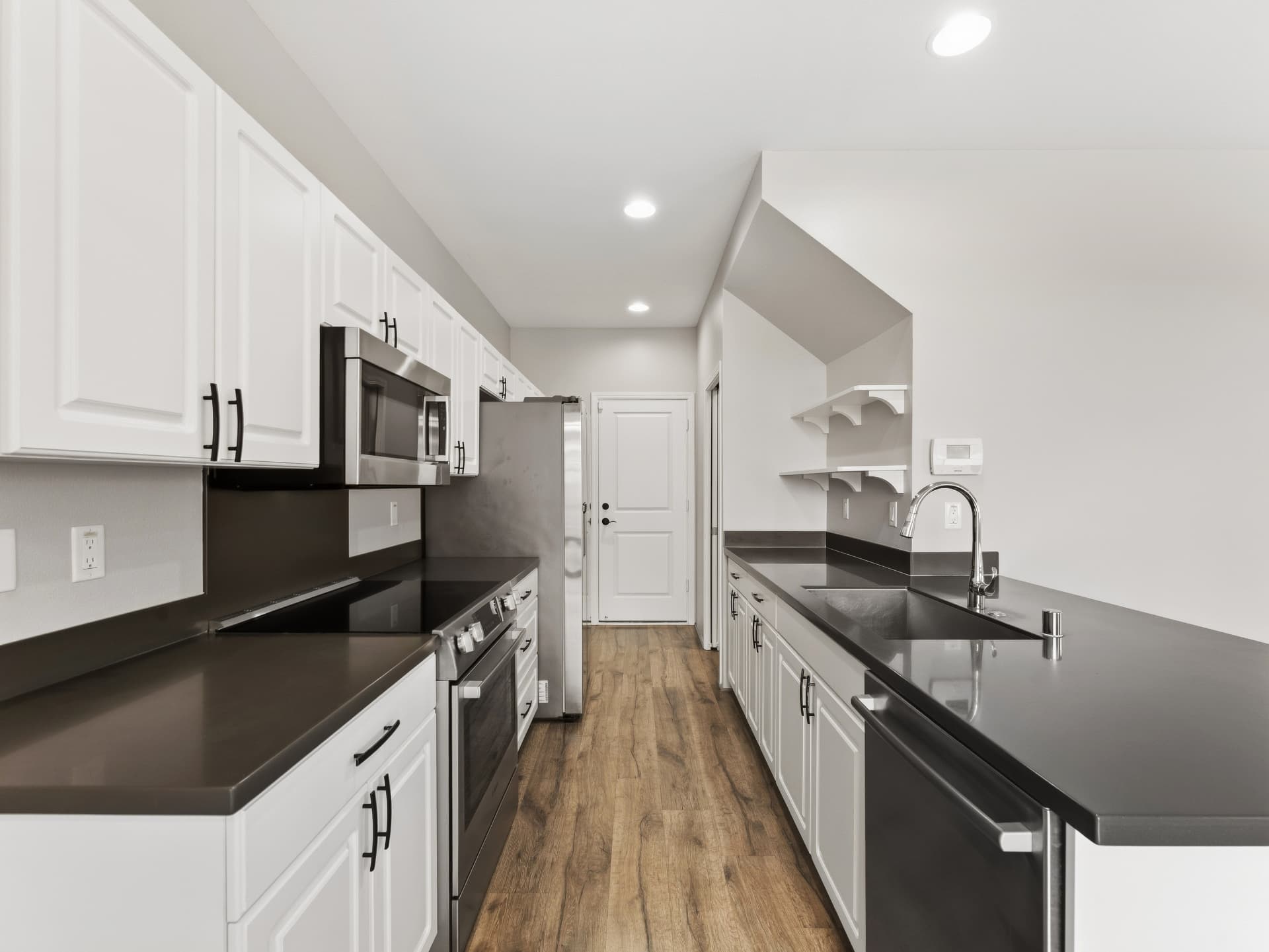 Galley kitchen with double sink, dishwasher and open shelving