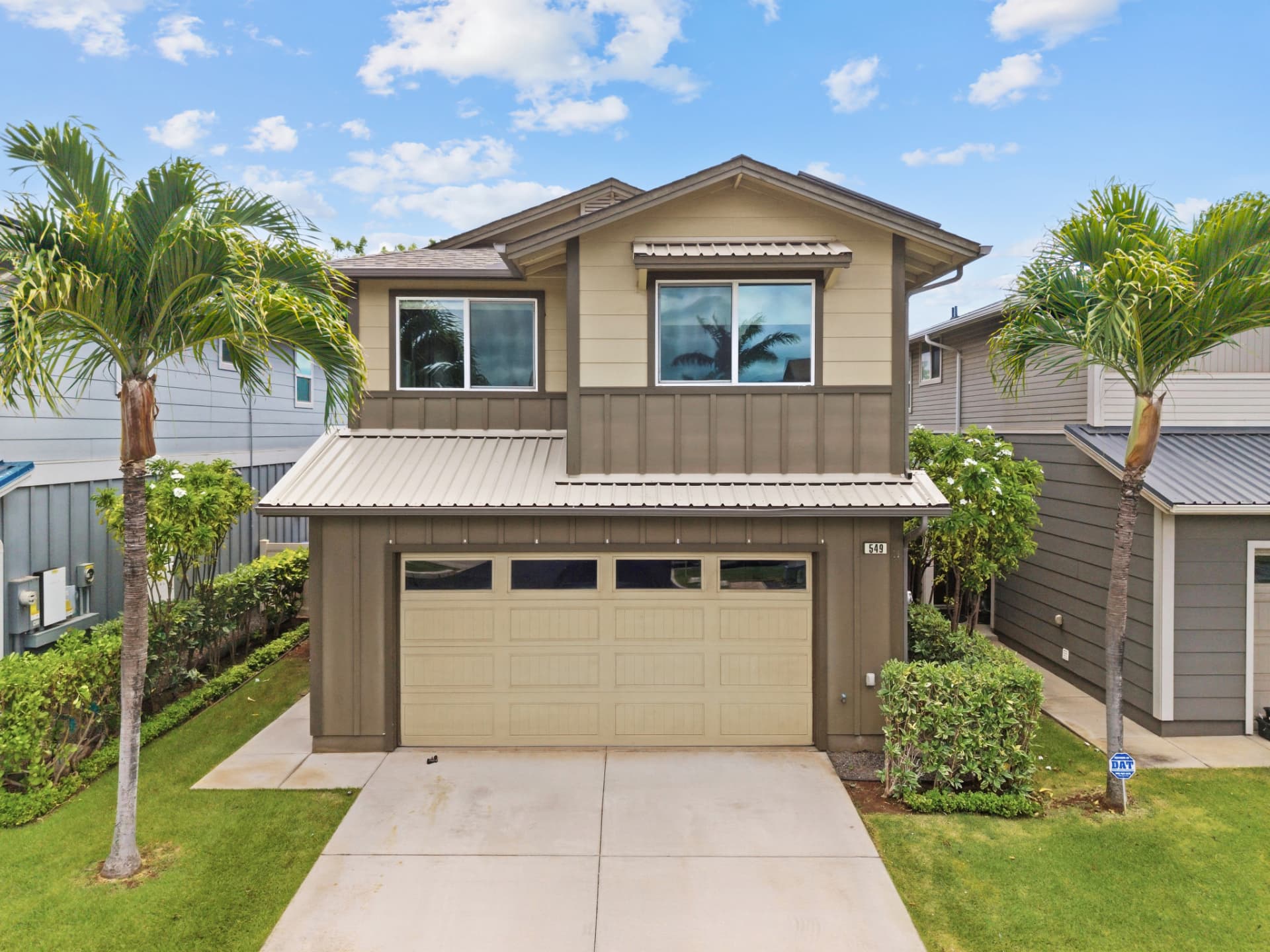Front of home with palm trees and two-car garage