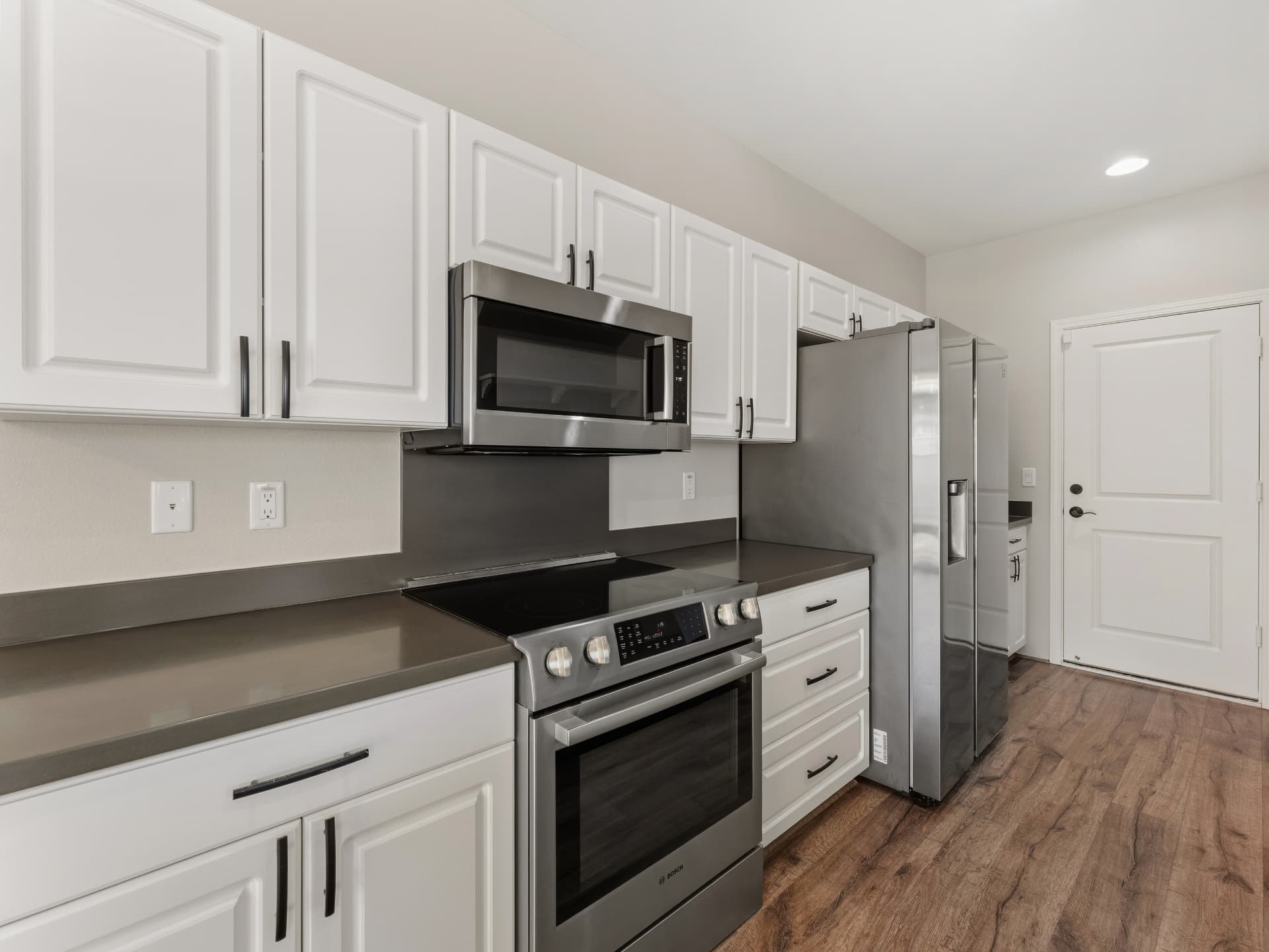Kitchen with white cabinetry, gas range and stainless appliances